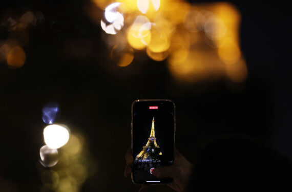 PARIS, Seorang pria merekam video Menara Eiffel yang bercahaya dengan ponselnya di Paris, Prancis, pada 22 September 2022. Mulai 23 September, lampu-lampu di Menara Eiffel akan dimatikan pada pukul 23.45 waktu setempat, tak lama setelah wisatawan terakhir meninggalkan lokasi itu, alih-alih pukul 01.00 yang diterapkan saat ini untuk membantu menghemat energi. (Xinhua/Gao Jing)