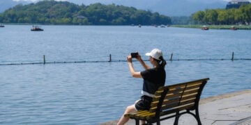 HANGZHOU, Seorang wisatawan mengabadikan foto kawasan wisata Danau Barat saat libur Hari Nasional China di Hangzhou, Provinsi Zhejiang, China timur, pada 2 Oktober 2022. (Xinhua/Xu Yu)