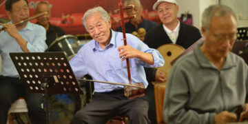 SHIJIAZHUANG, Liu Mingfei (tengah), yang berusia 80 tahun, terlihat sedang memainkan alat musik tradisional China Erhu dalam sebuah kelompok musik di Shijiazhuang, Provinsi Hebei, China utara, pada 2 Oktober 2022. Para warga lanjut usia (lansia) di China menikmati kehidupan pensiunan sambil menekuni hobi mereka. (Xinhua/Yan Zhiguo)