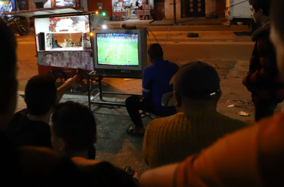 GAZA CITY, Orang-orang menonton pertandingan Piala Dunia FIFA 2022 Qatar yang disiarkan televisi di sebuah jalan di Gaza City pada 23 November 2022. (Xinhua/Rizek Abdeljawad)