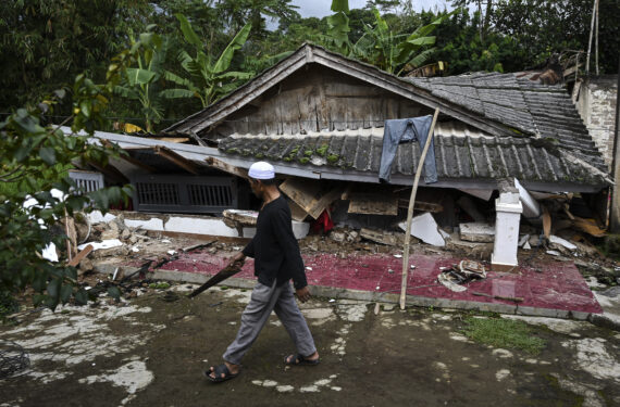 CIANJUR, Seorang warga berjalan di depan sebuah rumah yang rusak di Desa Mangunkerta di Cianjur, Provinsi Jawa Barat, pada 24 November 2022. Gempa kuat yang mengguncang Provinsi Jawa Barat pada Senin (21/11) membuat 62.545 penduduk di Kabupaten Cianjur, salah satu daerah yang paling terdampak parah gempa, terpaksa mengungsi, dan sebanyak 14 posko pengungsian telah didirikan, menurut Kepala Badan Nasional Penanggulangan Bencana (BNPB) Letjen TNI Suharyanto pada Kamis (24/11). (Xinhua/Veri Sanovri)