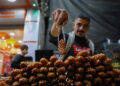 GAZA CITY, Seorang pedagang menunjukkan penganan manis Luqmat al-Qadi, kue tradisional yang terbuat dari adonan beragi dan digoreng, di sebuah pasar di Gaza City pada 27 November 2022. (Xinhua/Rizek Abdeljawad)
