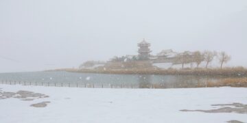 DUNHUANG, Foto yang diabadikan pada 27 November 2022 ini memperlihatkan pemandangan salju objek wisata Gunung Mingsha dan Mata Air Bulan Sabit di Kota Dunhuang, Provinsi Gansu, China barat laut. (Xinhua/Zhang Xiaoliang)