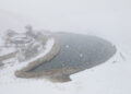 DUNHUANG, Foto dari udara yang diabadikan pada 27 November 2022 ini memperlihatkan pemandangan salju objek wisata Gunung Mingsha dan Mata Air Bulan Sabit di Kota Dunhuang, Provinsi Gansu, China barat laut. (Xinhua/Zhang Xiaoliang)