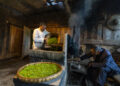 CHENGDU, Zhang Yuehua (kiri) mengolah daun teh dengan cara tradisional di rumah leluhurnya di Distrik Mingshan, Kota Ya'an, Provinsi Sichuan, China barat daya, pada 31 Maret 2022. Zhang, pria kelahiran 1959, merupakan perwakilan pewaris teknik pembuatan teh hijau. Memiliki sejarah panjang budi daya teh, Ya'an merupakan tempat lahirnya teknik pembuatan teh hitam dan teh hijau. Diwariskan dari generasi ke generasi, kedua teknik itu kini terdaftar sebagai warisan budaya takbenda tingkat nasional di China. (Xinhua/Shen Bohan)