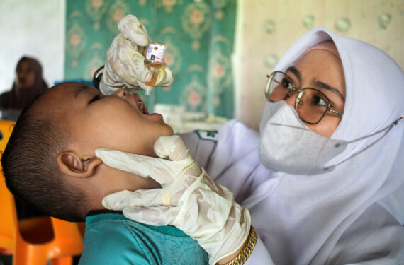 ACEH, Tenaga kesehatan memberikan vaksin polio tetes kepada seorang anak dalam Pekan Imunisasi Nasional di Desa Meunasah Langa, Kabupaten Aceh Utara, Provinsi Aceh, pada 5 Desember 2022. (Xinhua/Fachrul Reza)