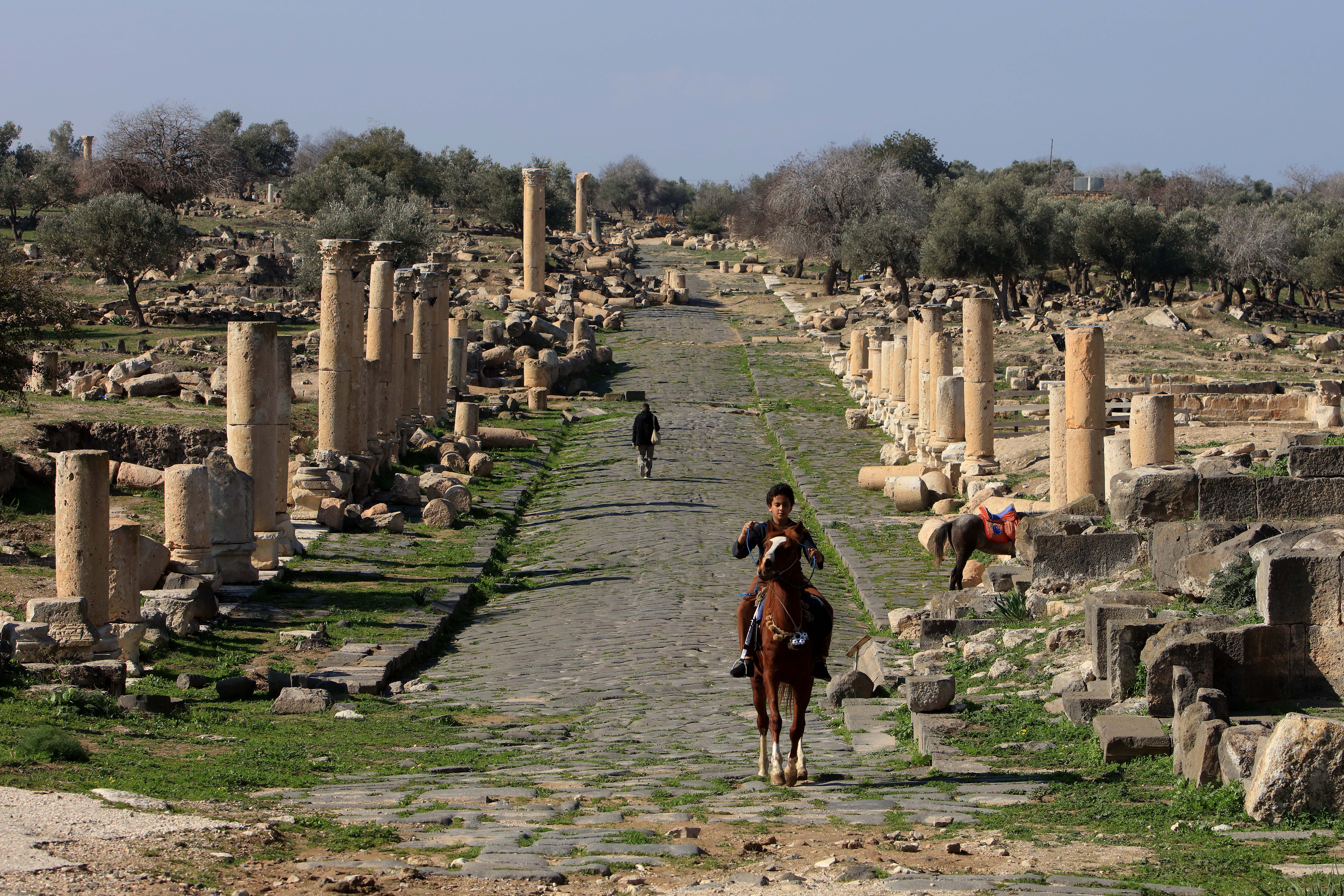UMM QAIS, Seorang anak laki-laki menunggang kuda di sebuah situs arkeologi di Umm Qais, Yordania, pada 17 Januari 2023. (Xinhua/Mohammad Abu Ghosh)