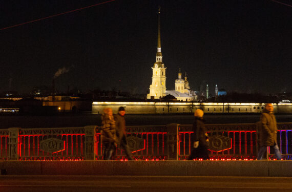 ST. PETERSBURG, Sejumlah pejalan kaki melintas di Palace Bridge yang diterangi cahaya merah dalam rangka merayakan Tahun Baru Imlek di St. Petersburg, Rusia. (Xinhua/Irina Motina)