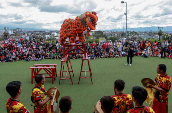 MALANG, Orang-orang menyaksikan pertunjukan barongsai dalam perayaan Tahun Baru Imlek di Malang, Provinsi Jawa Timur, pada 22 Januari 2023. (Xinhua/Bayu Novanta)