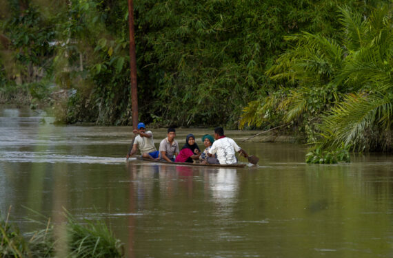 ACEH UTARA, Sejumlah warga mendayung perahu kayu melewati genangan banjir usai hujan deras di Gampong Buket Linteung, Kabupaten Aceh Utara, Provinsi Aceh, pada 23 Januari 2023. (Xinhua/Fachrul Reza)