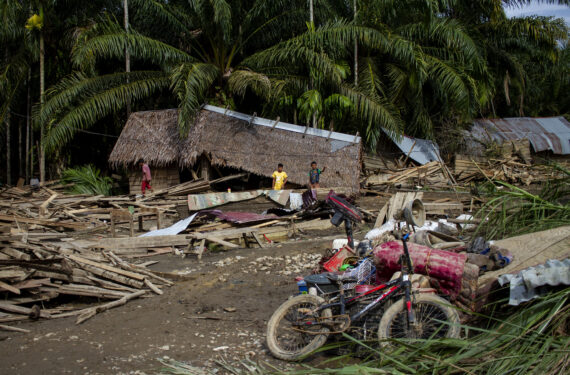 ACEH UTARA, Sejumlah anak kecil berdiri di dekat rumah-rumah yang rusak akibat banjir yang disebabkan oleh hujan deras di Gampong Lubok Pusaka, Kabupaten Aceh Utara, Provinsi Aceh, pada 23 Januari 2023. (Xinhua/Fachrul Reza)