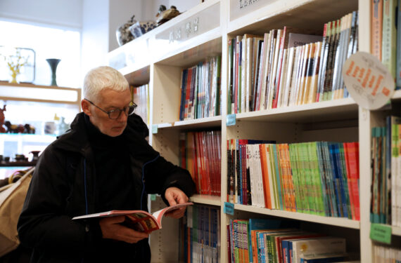 LONDON, Marcus Broadbent membaca di Toko Buku Guanghwa yang berlokasi di London, Inggris, pada 24 Januari 2023. (Xinhua/Li Ying)