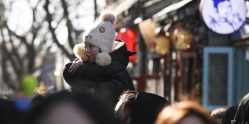 BEIJING, Seorang anak menikmati makanan di Jalan Nanluoguxiang di Beijing, ibu kota China, pada 27 Januari 2023. Warga menikmati hari terakhir liburan Festival Musim Semi atau Tahun Baru Imlek pada Jumat (27/1). (Xinhua/Lan Hongguang)