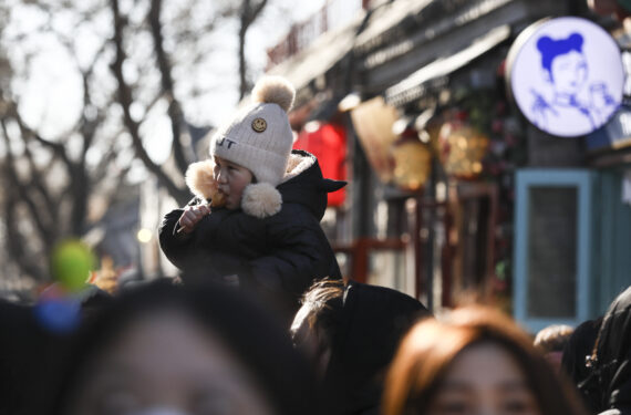 BEIJING, Seorang anak menikmati makanan di Jalan Nanluoguxiang di Beijing, ibu kota China, pada 27 Januari 2023. Warga menikmati hari terakhir liburan Festival Musim Semi atau Tahun Baru Imlek pada Jumat (27/1). (Xinhua/Lan Hongguang)