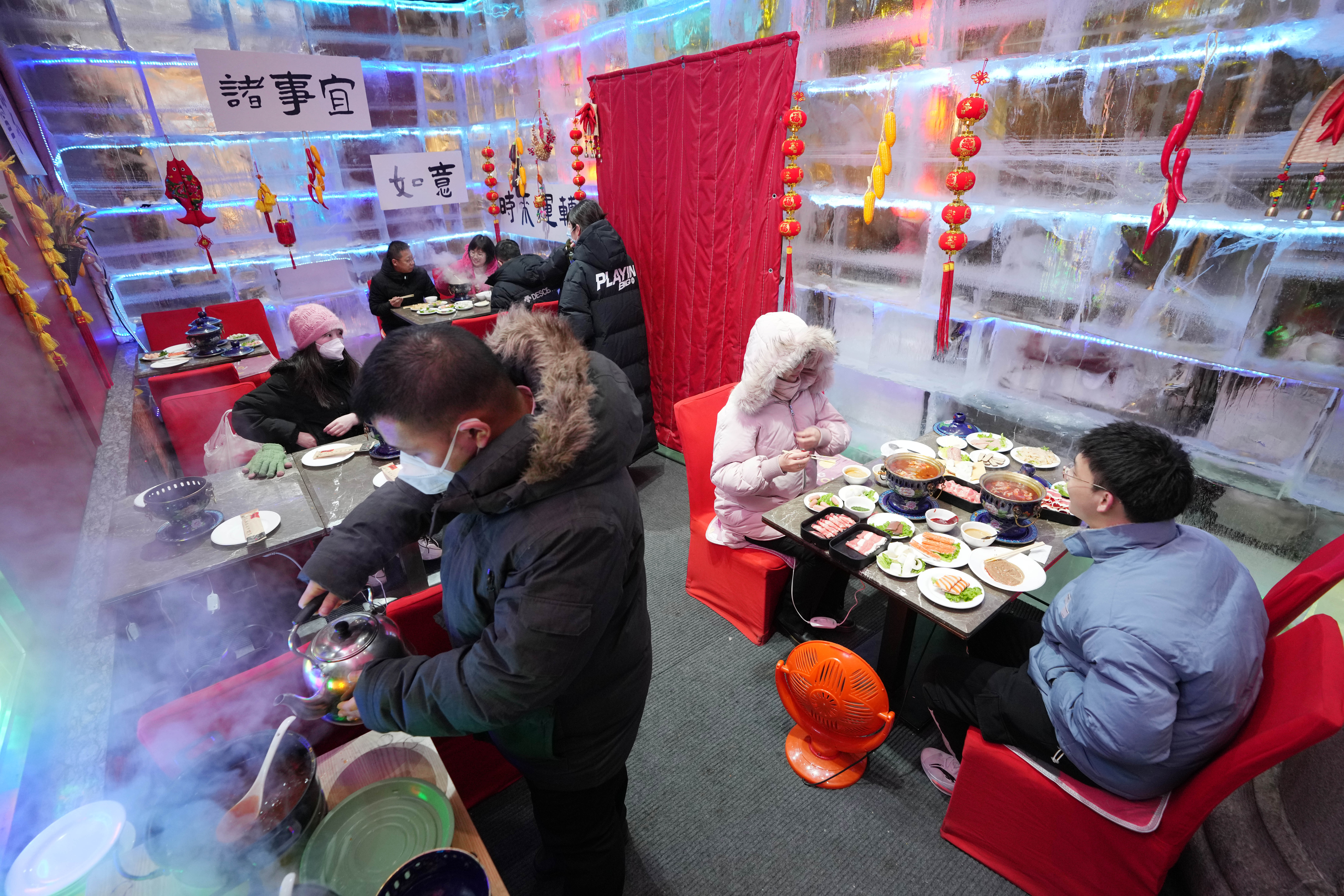 HARBIN, Sejumlah wisatawan menikmati hidangan hotpot di sebuah stan yang terbuat dari es di Central Street di Harbin, Provinsi Heilongjiang, China timur laut, pada 28 Januari 2023. Sebuah pameran makanan dengan stan-stan yang terbuat dari es di Central Street menjadi tujuan wisata populer seiring pesatnya perkembangan pariwisata es dan salju di Harbin. (Xinhua/Wang Jianwei)