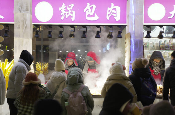 HARBIN, Para wisatawan membeli makanan ringan di Central Street di Harbin, Provinsi Heilongjiang, China timur laut, pada 28 Januari 2023. Sebuah pameran makanan dengan stan-stan yang terbuat dari es di Central Street menjadi tujuan wisata populer seiring pesatnya perkembangan pariwisata es dan salju di Harbin. (Xinhua/Wang Jianwei)