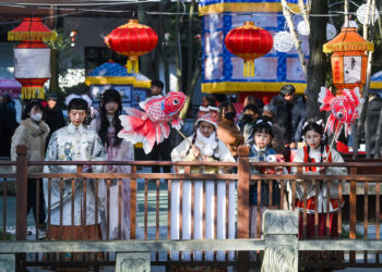 JIAXING, Para wisatawan yang mengenakan kostum tradisional China mengamati lampion-lampion dalam Festival Lampion Aoshan di kota kuno Xincheng yang terletak di Distrik Xiuzhou di Jiaxing, Provinsi Zhejiang, China timur, pada 29 Januari 2023. Festival Lampion Aoshan, yang memiliki sejarah ratusan tahun, resmi dibuka di Jiaxing pada Minggu (29/1). (Xinhua/Xu Yu)