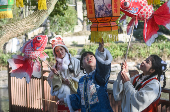 JIAXING, Para wisatawan yang mengenakan kostum tradisional China mengamati lampion-lampion dalam Festival Lampion Aoshan di kota kuno Xincheng yang terletak di Distrik Xiuzhou di Jiaxing, Provinsi Zhejiang, China timur, pada 29 Januari 2023. Festival Lampion Aoshan, yang memiliki sejarah ratusan tahun, resmi dibuka di Jiaxing pada Minggu (29/1). (Xinhua/Xu Yu)