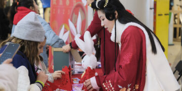 SLIEMA, Anak-anak belajar melipat lampion yang bertuliskan aksara Mandarin "fu", yang berarti keberuntungan, di Sliema, Malta, pada 28 Januari 2023. Acara perayaan Tahun Baru Imlek atau Festival Musim Semi digelar di sebuah pusat perbelanjaan di Sliema pada Sabtu (28/1). (Xinhua/Jonathan Borg)