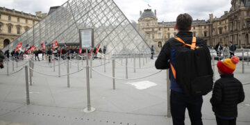 PARIS, Sejumlah wisatawan menyaksikan para pegawai Museum Louvre dan situs budaya lainnya memblokade pintu masuk Museum Louvre di Paris, Prancis, pada 27 Maret 2023, untuk memprotes reformasi pensiun pemerintah. (Xinhua/Gao Jing)