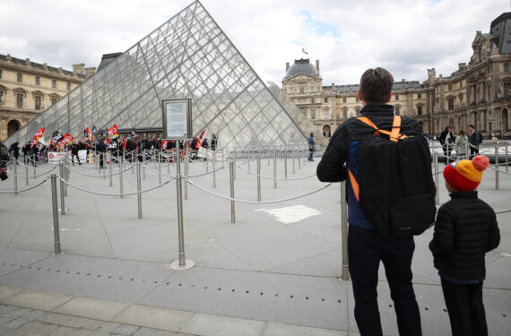 PARIS, Sejumlah wisatawan menyaksikan para pegawai Museum Louvre dan situs budaya lainnya memblokade pintu masuk Museum Louvre di Paris, Prancis, pada 27 Maret 2023, untuk memprotes reformasi pensiun pemerintah. (Xinhua/Gao Jing)