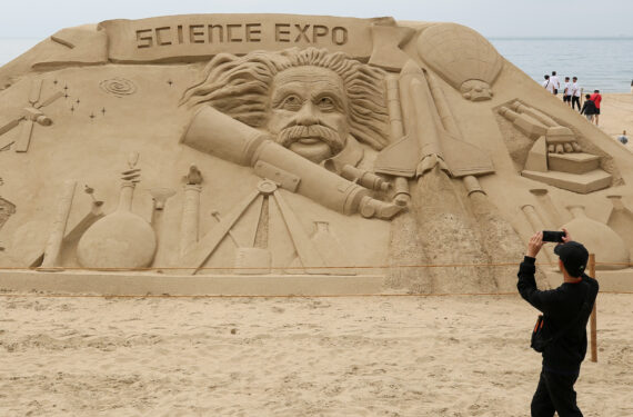 BUSAN, Seorang wisatawan memotret sebuah patung pasir di Pantai Haeundae di Busan, Korea Selatan, pada 26 Mei 2023. (Xinhua/Wang Yiliang)