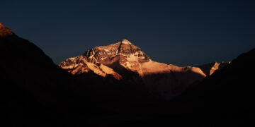 TINGRI, Foto yang diabadikan pada 4 Juni 2023 ini memperlihatkan pemandangan Gunung Qomolangma saat matahari terbenam di Daerah Otonom Tibet, China barat daya. (Xinhua/Fei Maohua)